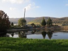 Der Kran, die Baustelle und die umliegende Landschaft spiegeln sich im Baumschulsee [28. Oktober 2014]